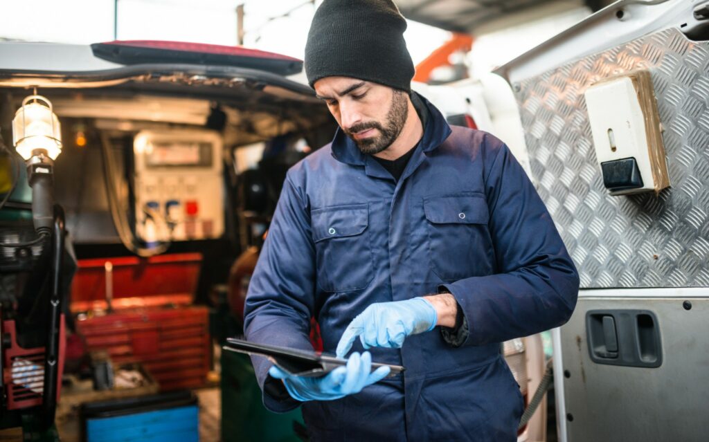 A worker references his tablet while working out of a truck. 