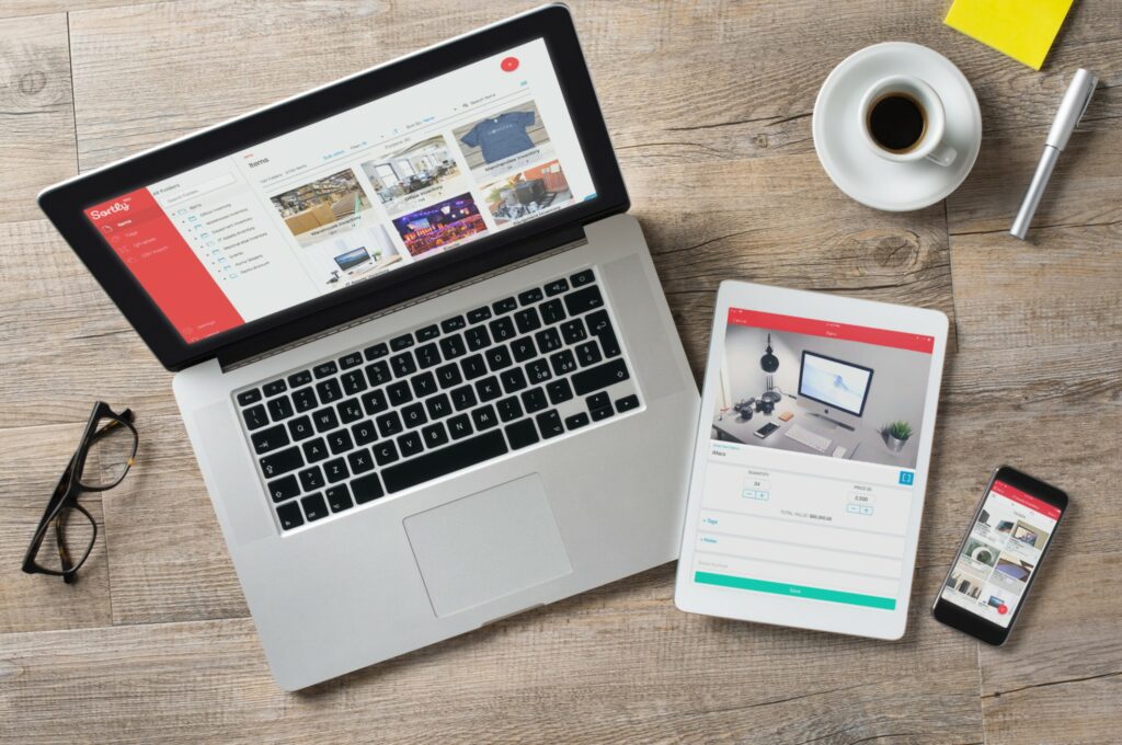 Sortly inventory management software is shown on a tablet, laptop and phone. 