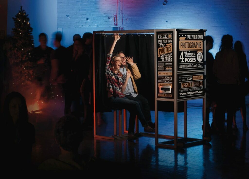 A modern photobooth at an event. A woman strikes a pose.