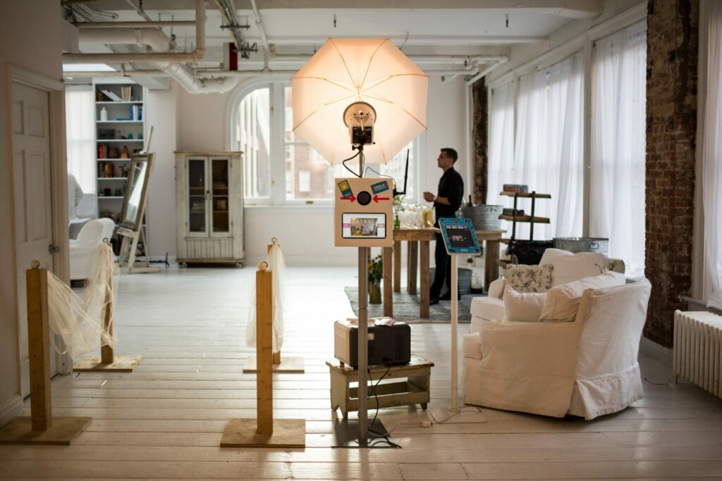 Photography equipment in a room full of natural light. A man sets up the equipment.